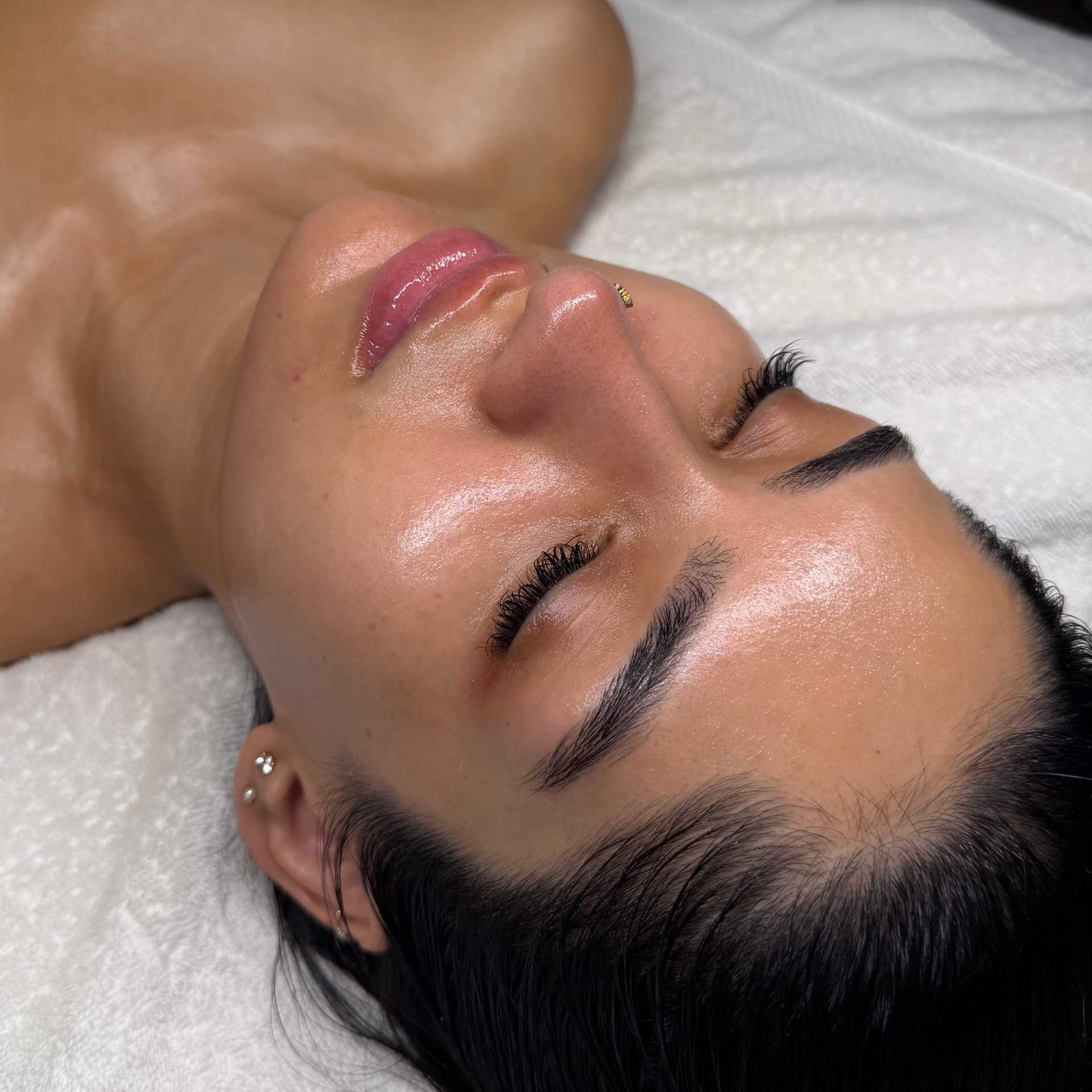 Smooth-skinned woman relaxing during a facial treatment.